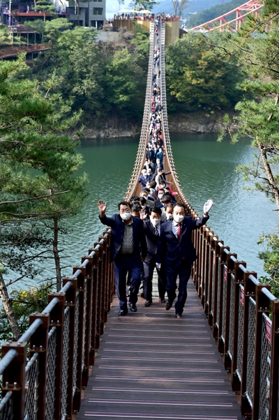 이상천 시장, 배동만 시의회 의장과 시의원, 엄태영 국회의원 등 50여명이 '제천 옥순봉 출렁다리'를 건너고 있다. /제천시 제공