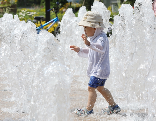 청주의 낮 최고기온이 31도까지 치솟아 한여름 날시를 보인 22일 오후 분수대에서 한 어린이가 물놀이를 하고 있다. /뉴시스